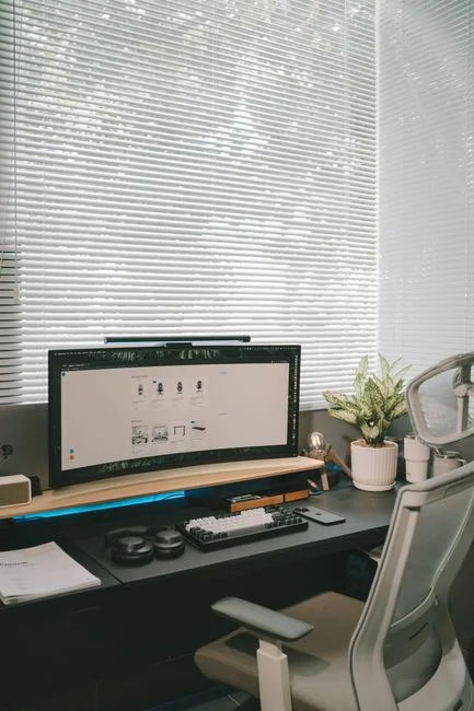 A Lenovo laptop displaying Facebook login beside a lavender plant indoors.